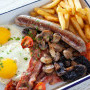 Skippers Breakfast - Two free range eggs served with bacon, local beef boerewors, sautéed mushrooms, roasted cherry tomato’s and chips *bacon can be substituted with mac.